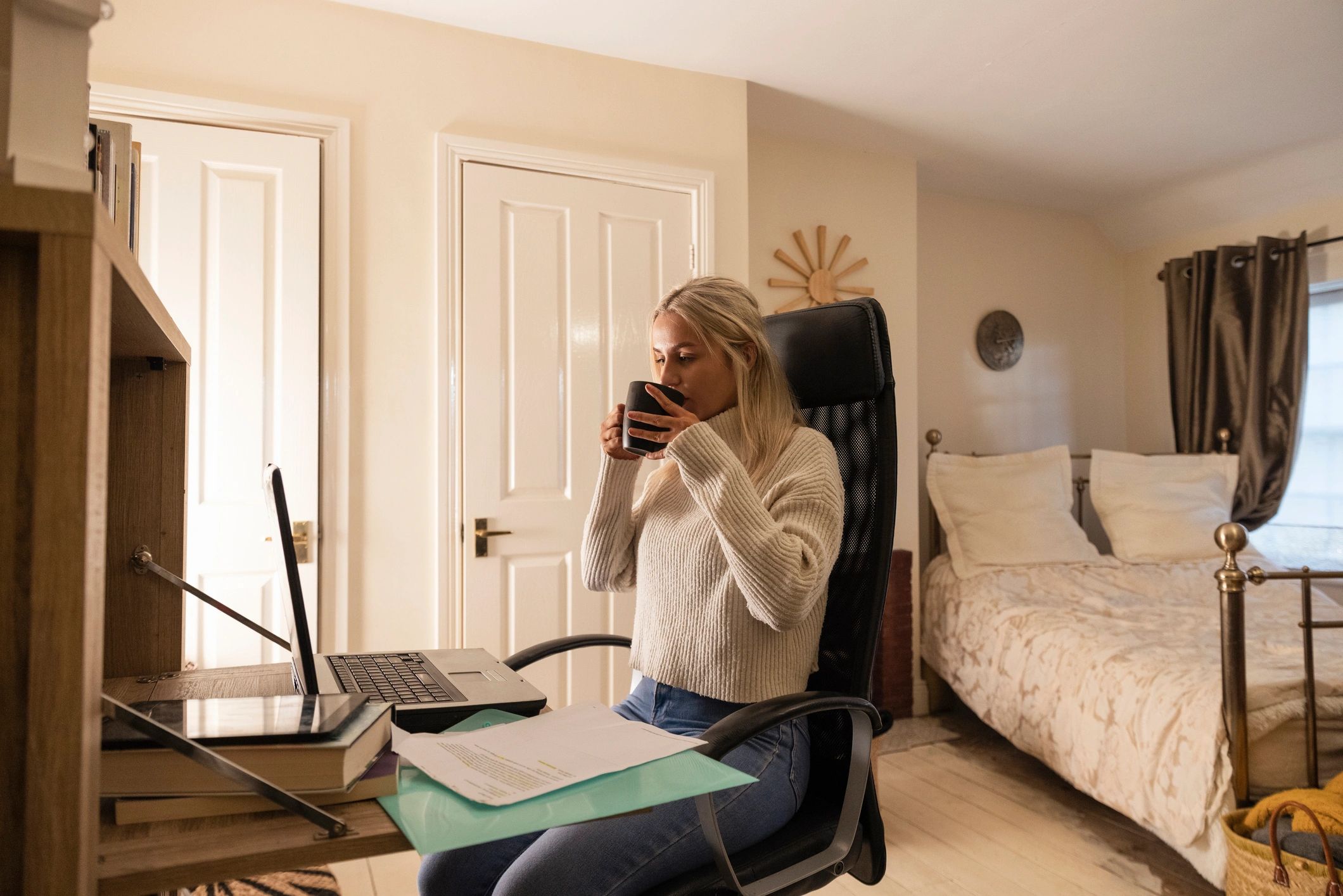 Writer working comfortably at home with laptop and notebook