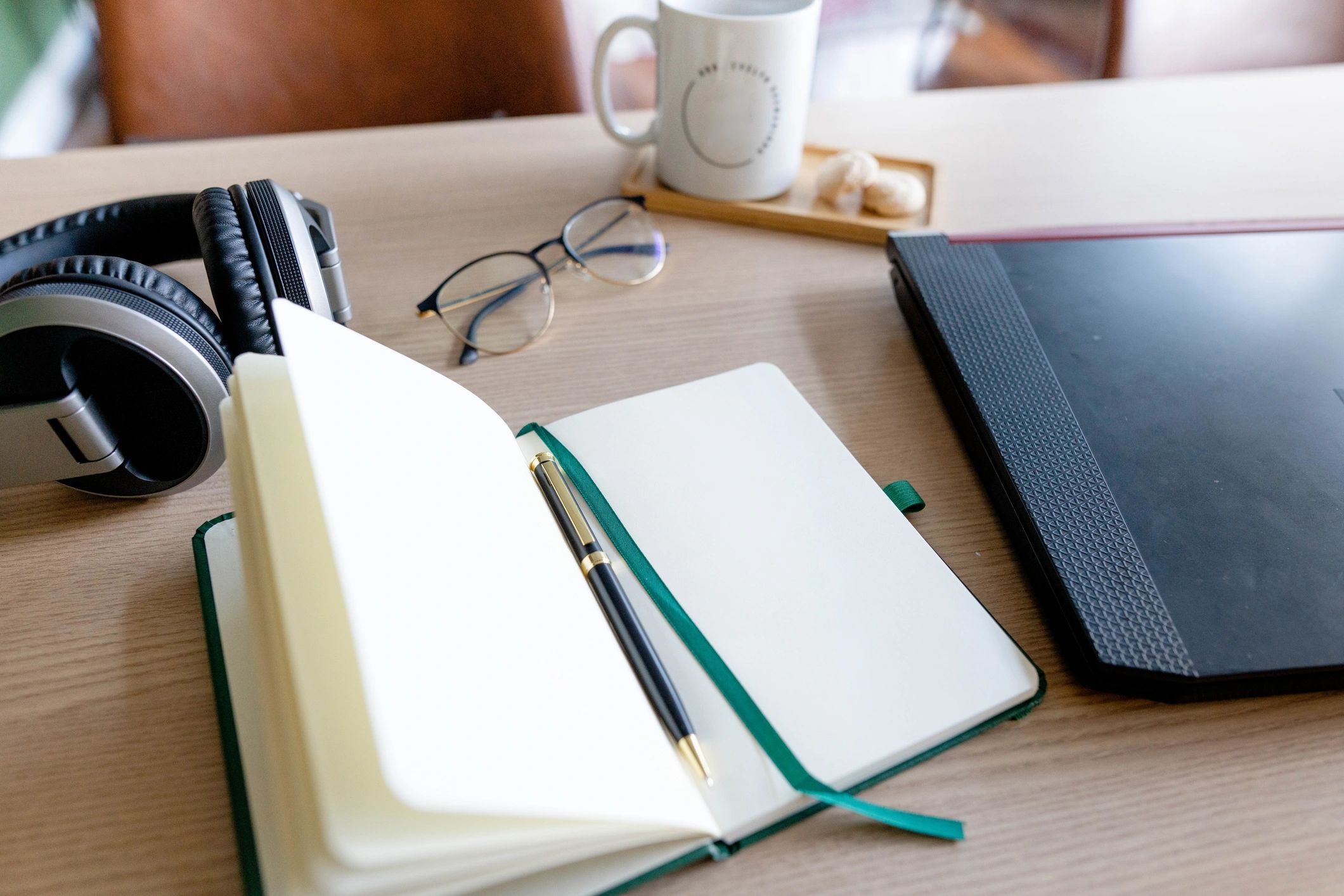 Notebook and laptop on a desk for monthly writing planning