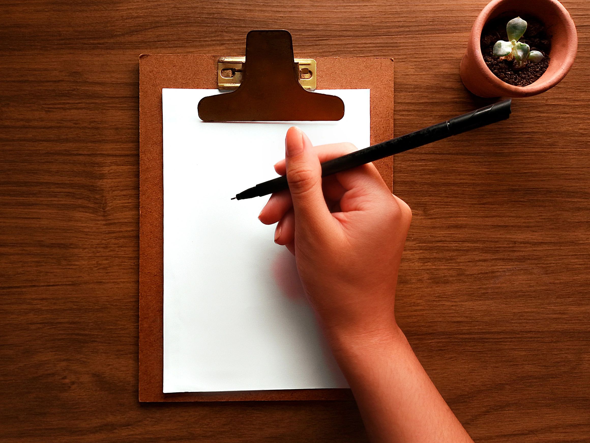 Writing notebook and coffee on a wooden desk