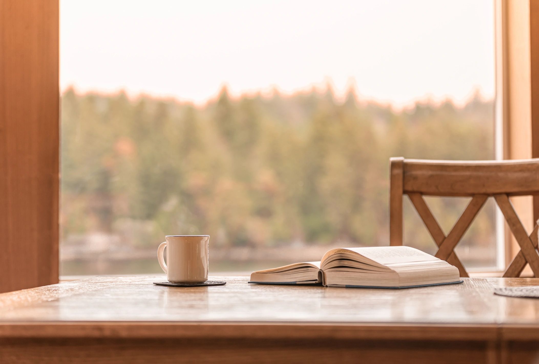 Open book and coffee by a window for cozy reading inspiration