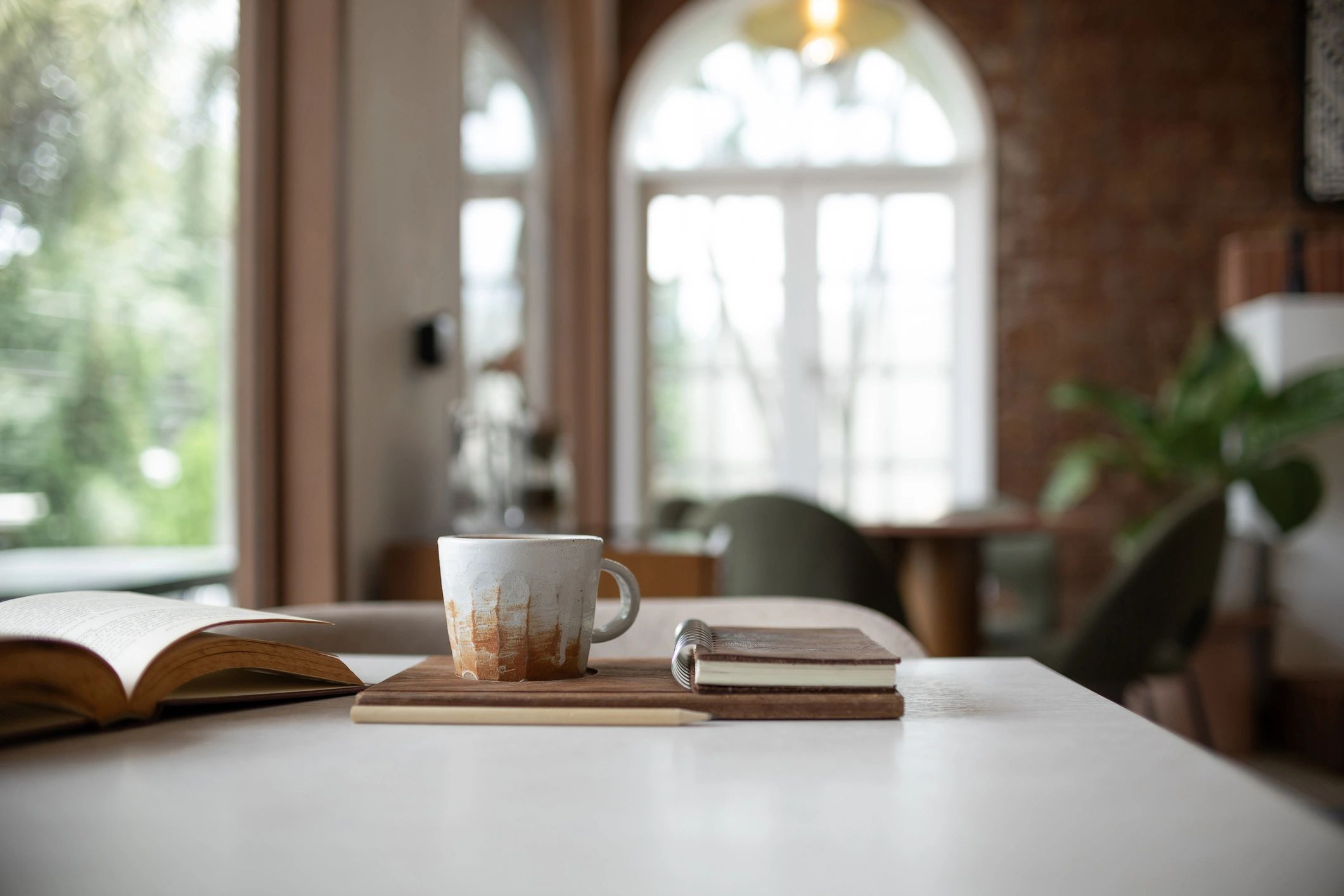 Coffee cup beside books and journal on a quiet table