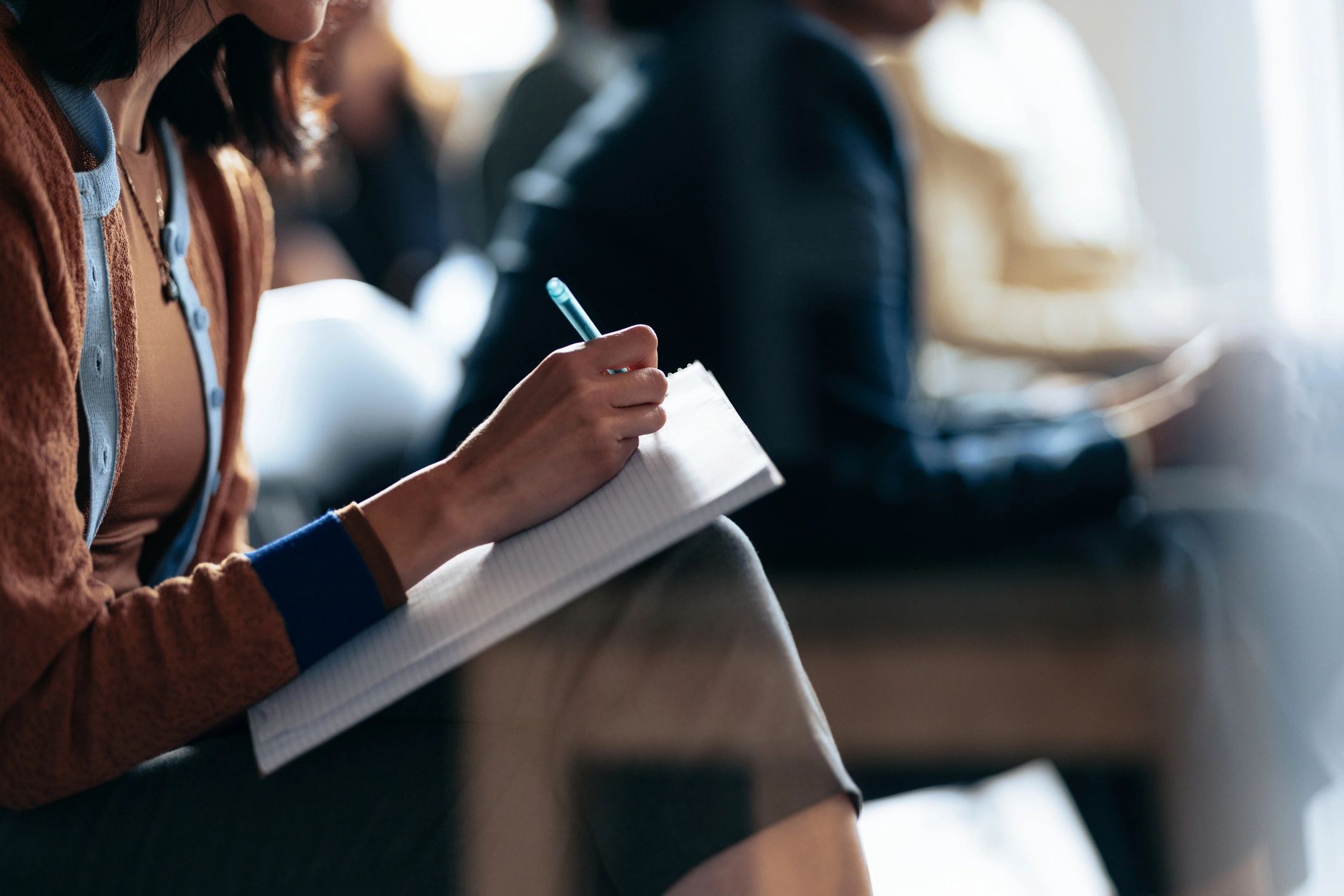 Person taking notes during a webinar or seminar