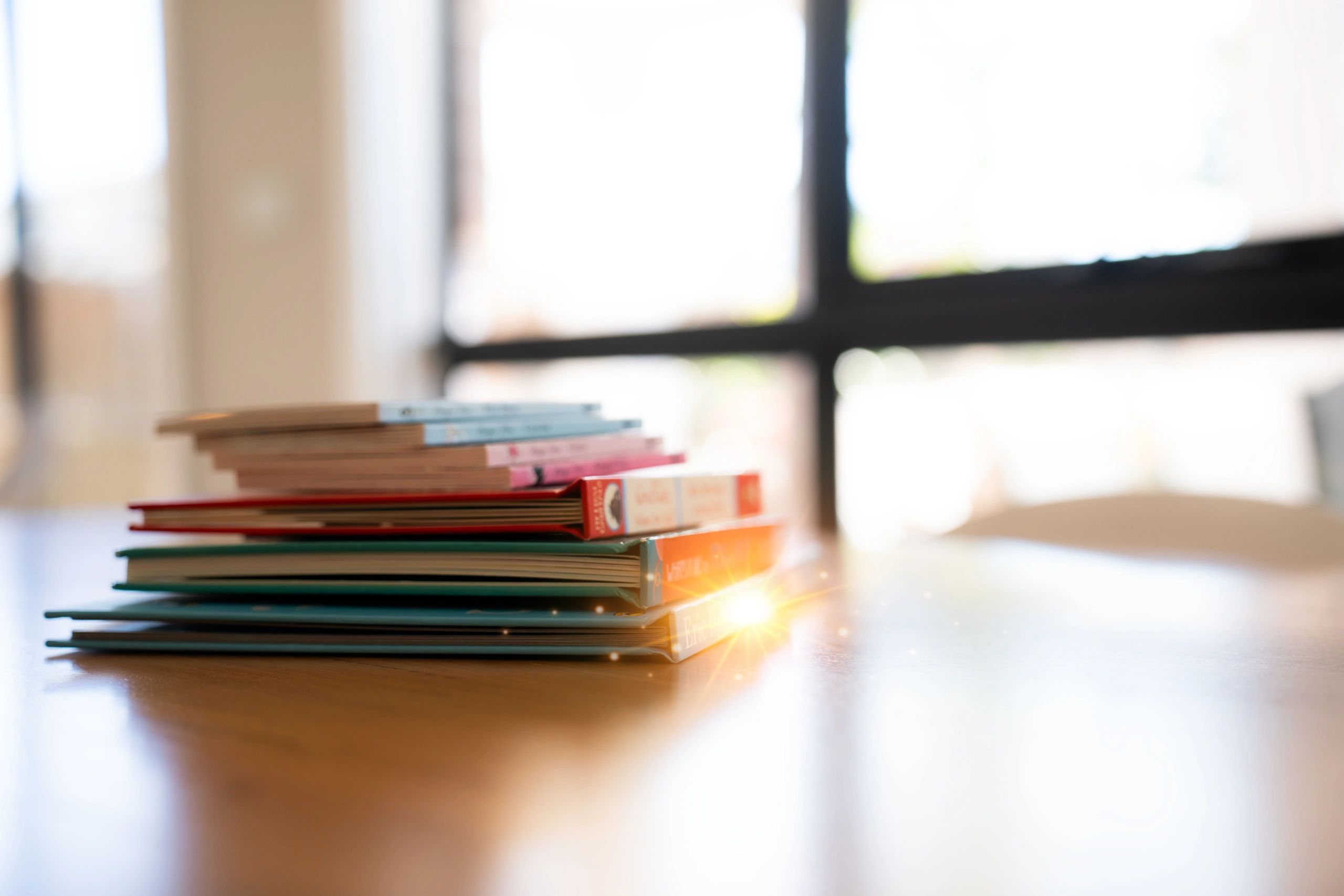 Stack of books on a wooden desk